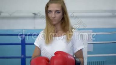 戴拳击手套的严肃女运动员在健身房打拳击前会感到温暖
